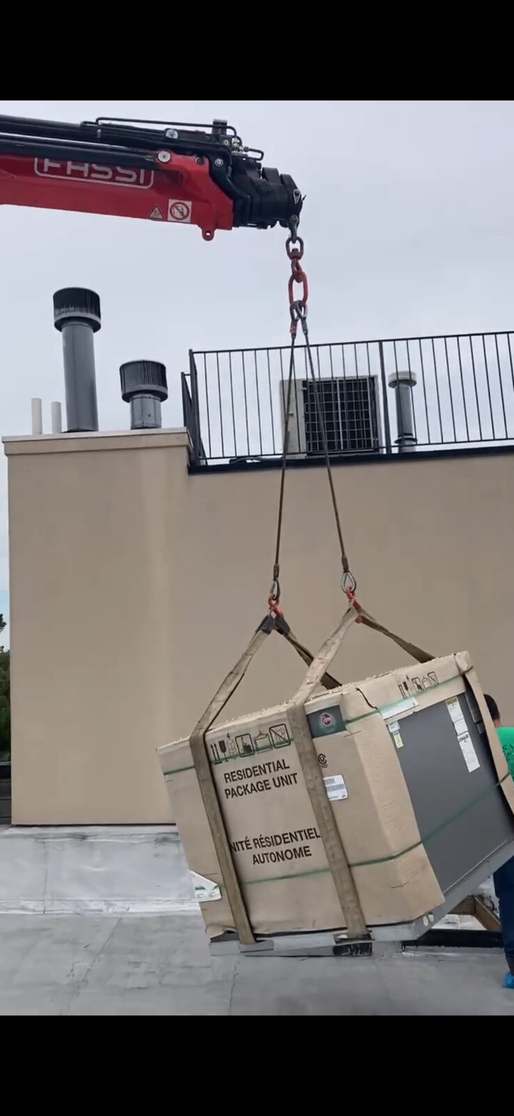 New residential package HVAC unit being craned up to a Brooklyn rooftop