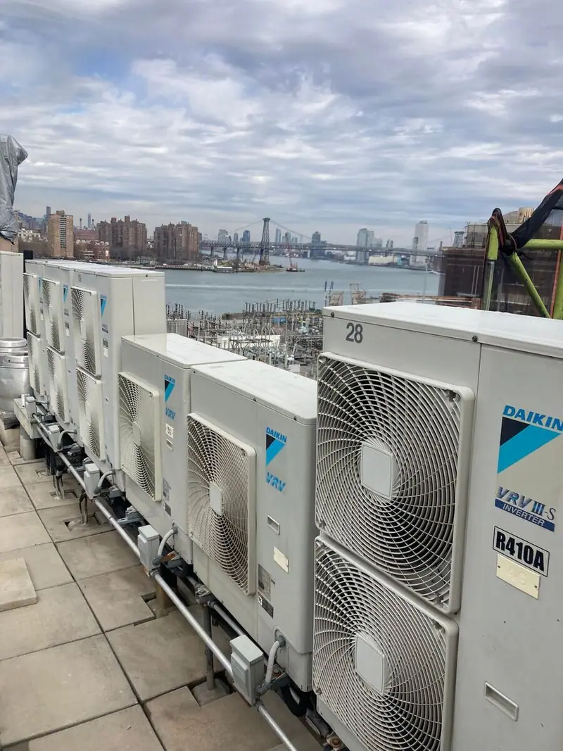 Daikin VRV condensers on a Brooklyn rooftop with the Williamsburg Bridge in the background