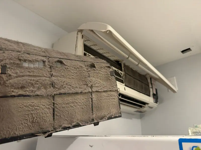 Filthy mini split filter pulled from a Brooklyn ductless head after one unmaintained season