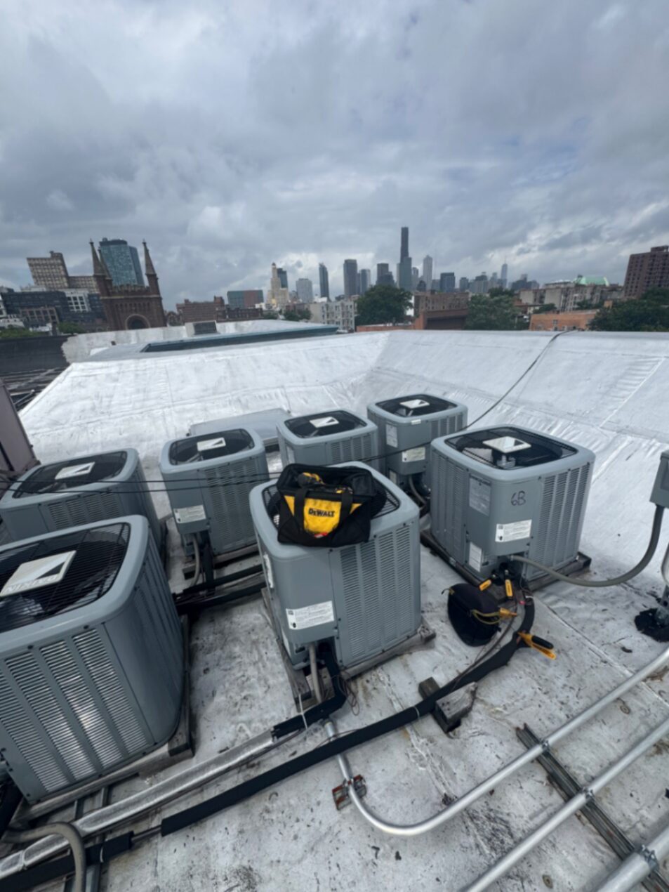 Brooklyn HVAC installation — multi-unit rooftop condenser array with downtown Brooklyn skyline